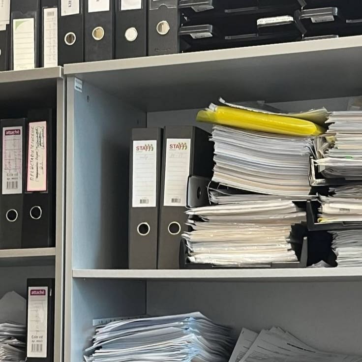 A stack of official certificates and transcripts on a desk
