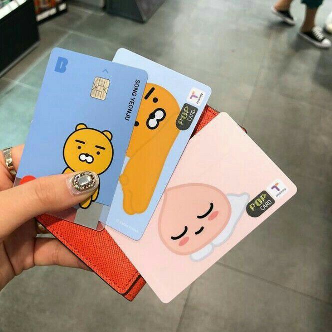 A T-money card held in front of a subway fare gate