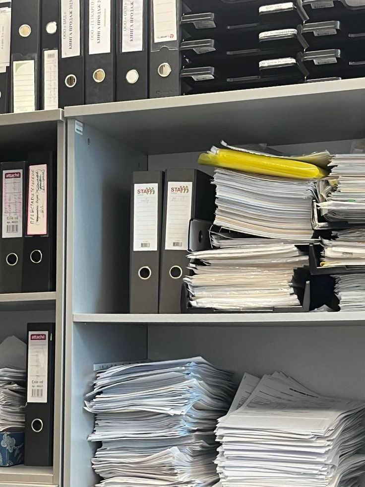 A hand checking documents and figures at a desk
