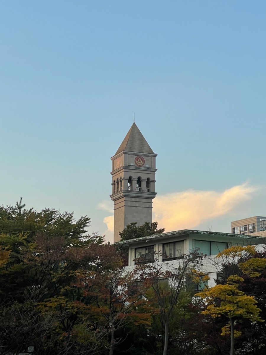 A university campus building behind a green lawn