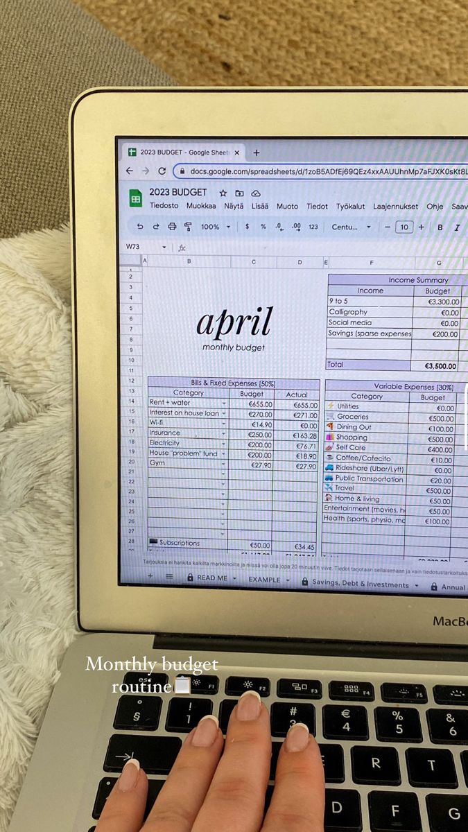 A hand using a phone calculator over a stack of documents