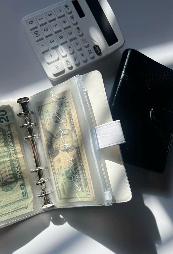 A student planning a monthly budget with a phone and notebook